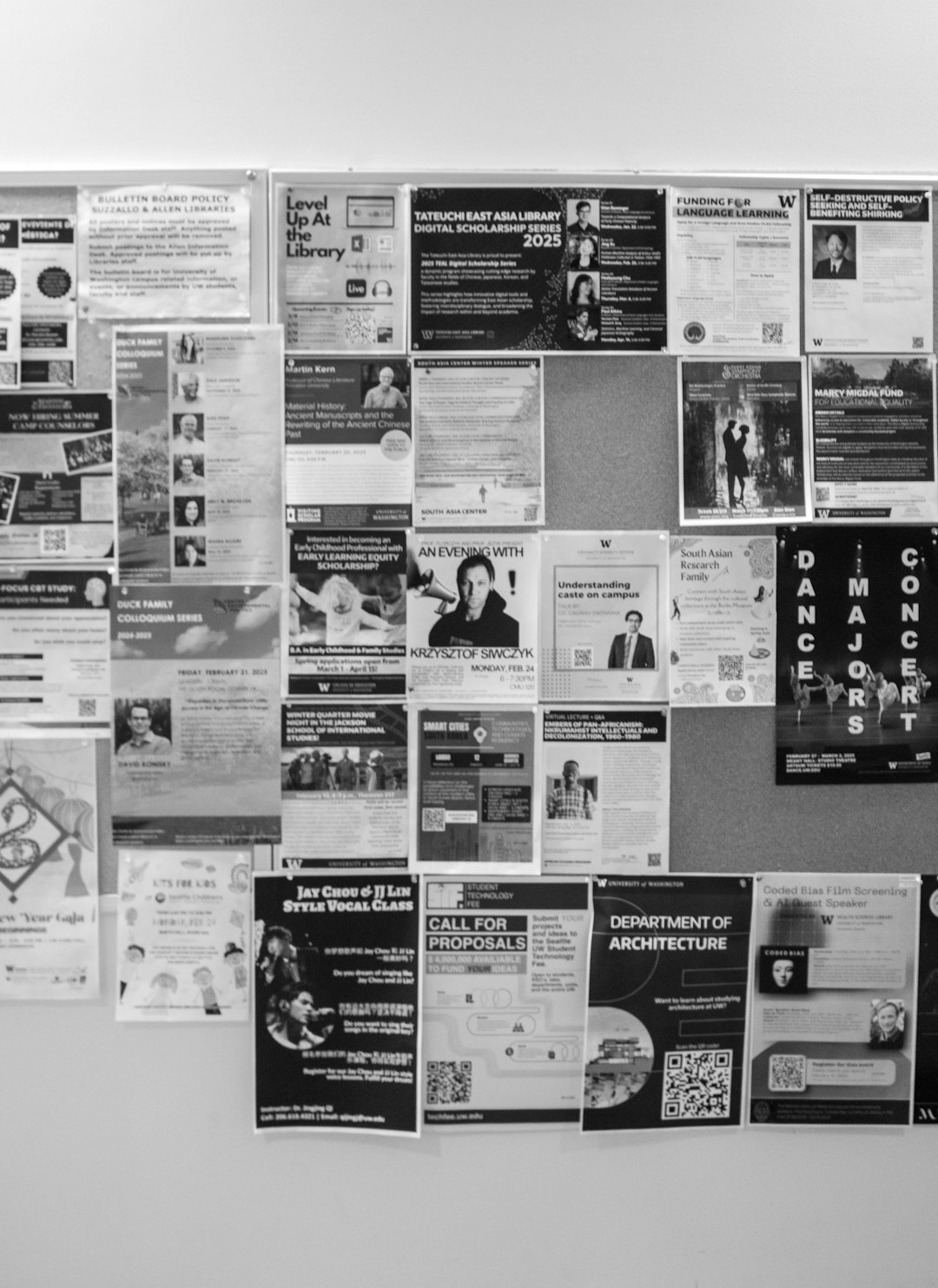 Small editorial office with printed photographs pinned to a corkboard wall