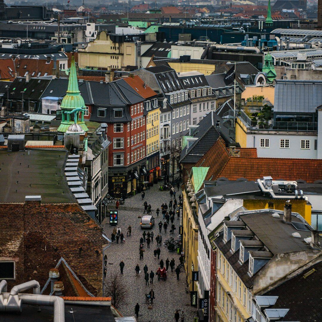 Overhead view of a desk with a camera, notebook and printed photographs of Danish streets